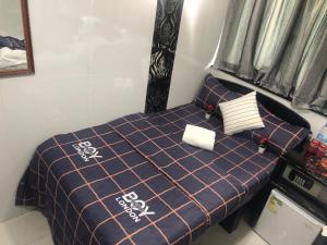 a bedroom with a bed with a blue blanket and pillows at Australia Lounge in Hong Kong