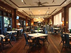 a restaurant with tables and chairs and a bar at Palm Beach Resort & SPA in Labuan