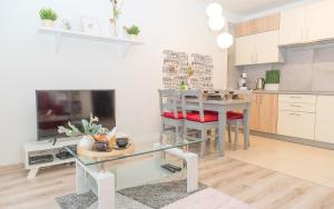 ein Wohnzimmer mit einem Tisch und einer Küche in der Unterkunft EASY RENT Apartments - COZY in Lublin