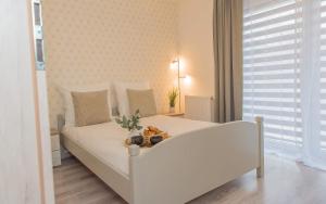 Ein weißes Bett in einem kleinen Zimmer mit in der Unterkunft EASY RENT Apartments - COZY in Lublin