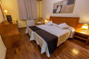 A bed or beds in a room at Hotel de Montaña Rubielos