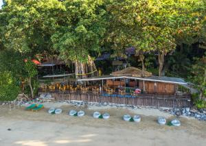 ein Restaurant am Strand mit Tischen und Stühlen in der Unterkunft Koh Jum Ocean Beach Resort in Ko Jum