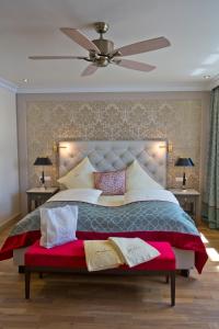 - une chambre avec un grand lit et un ventilateur de plafond dans l'établissement Mokni's Palais Hotel & SPA, à Bad Wildbad