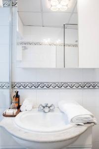 a white bathroom with a sink and a mirror at Escape to Paradise in St Paul's Bay