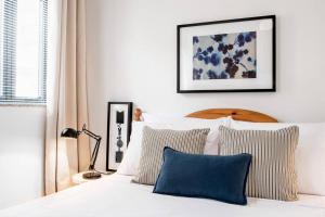 1 dormitorio con cama blanca y almohadas azules en Escape to Paradise, en St Paul's Bay