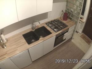 una pequeña cocina con fogones y fregadero en Rent0nline Brwinow Rooms, en Brwinów