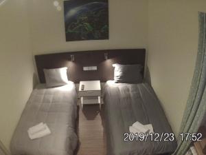 a room with two beds and a table in it at Rent0nline Brwinow Rooms in Brwinów