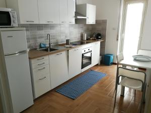 a kitchen with white cabinets and a sink at Casa Levante Sea View Apartment in Catania