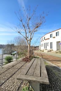 drewniana ławka obok drzewa na ulicy w obiekcie RestOnDouro Oporto w mieście Gondomar