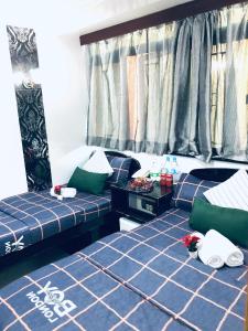 2 camas en una habitación con sábanas azules y almohadas verdes en Australia Lounge, en Hong Kong