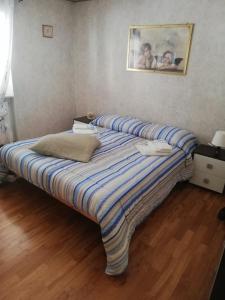 een groot bed met een gestreepte deken in een kamer bij Cif apartment 3 in Pastena