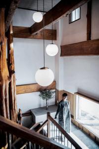 a man in a raincoat standing on a staircase in a building at The Apartment Hotels KOU in Otaru