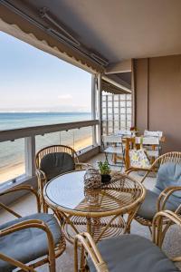 un comedor con mesa y sillas y el océano en Metaxa Seafront Apartment, en Perea