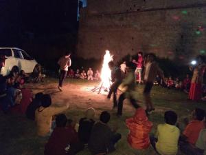 a group of people watching people dancing around a fire at Ooty Dormitories in Ooty