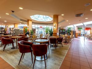 a restaurant with tables and chairs in a building at Hotel Göttingen-West in Rosdorf