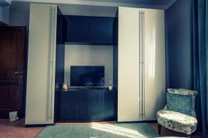 a living room with a tv and a chair at My Tuscany Suites in Castiglioncello
