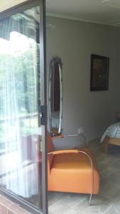 an orange bench in a room with a mirror at Otentik guesthouse in Mbabane