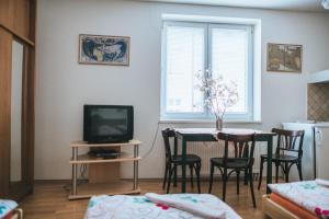 a living room with a table with chairs and a television at Klub U Námořníka in Dvůr Králové nad Labem