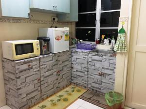 a small kitchen with a microwave and a sink at IRWAN FAIZ GUEST & HOMESTAY in Kampung Gita