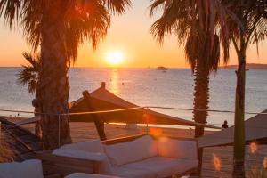 een zonsondergang op het strand met een bank en palmbomen bij Best Holiday Port Grimaud in Grimaud +86 foto's