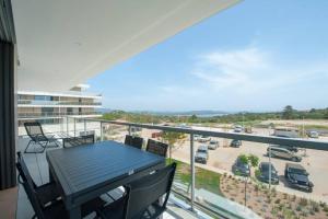 a balcony with a table and chairs and a parking lot at Bel appartement vue mer Porto Vecchio in Porto-Vecchio