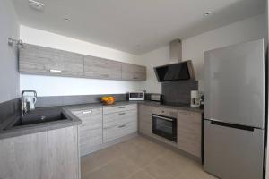 eine Küche mit einer Spüle und einem Kühlschrank in der Unterkunft Bel appartement vue mer Porto Vecchio in Porto-Vecchio