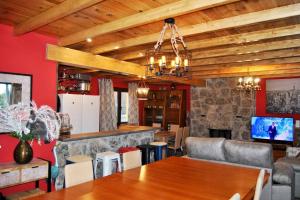 salon ze stołem i kominkiem w obiekcie Casa Rural Mansion Alejandra con piscina y jacuzzi w mieście Collado Mediano