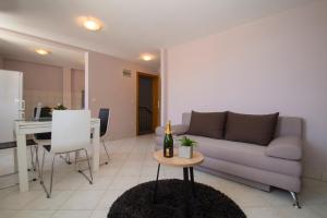 科爾丘拉的住宿－MILINA KORČULA，客厅配有沙发和一张桌子及一瓶葡萄酒