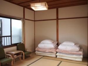 Guest House hachi hachi في كوياسان: غرفة بسريرين وكرسي ونافذة