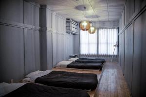 3 Betten in einem Zimmer mit Fenster in der Unterkunft The Apartment Hotels KOU in Otaru