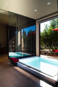 a swimming pool in a house with a large window at Masseria Li Reni in Manduria