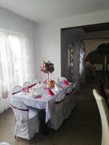 a dining room with a long table with red chairs at Restaurant Vi La Maria in Baia de Fier