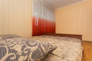 a bedroom with a bed and a red curtain at 2 room in Centre on Troitskaya 3 floor in Sumy