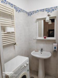 Baño blanco con lavabo y espejo en Napulè 10, en Nápoles