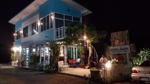 a group of people standing outside of a house at night at Mountain View Guest House in Phatthalung