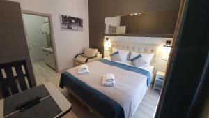 ein Hotelzimmer mit einem großen Bett mit Handtüchern darauf in der Unterkunft ANTARES Apart hotel in Lwiw