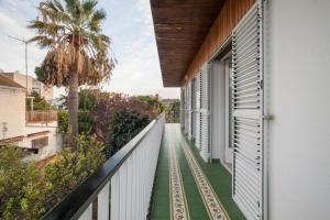 einen Balkon mit Grünboden und einem weißen Zaun in der Unterkunft Magnífica casa al lado de la playa in Castelldefels