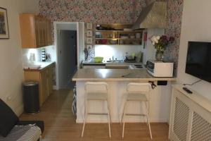 a kitchen with a counter and two bar stools at Cathedral apartment in Derry Londonderry