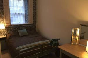 1 dormitorio con 1 cama, ventana y escritorio en Cathedral apartment en Derry