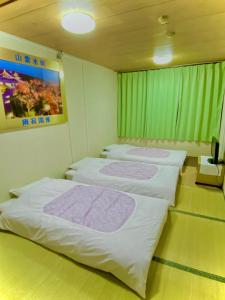 A bed or beds in a room at Hotel Houshi Kaikan