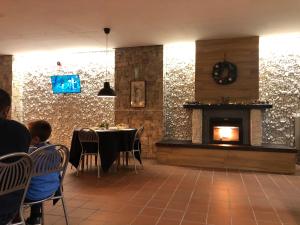 a dining room with a fireplace and people sitting at a table at Villaggio dello sciatore residence paradiso in Roccaraso