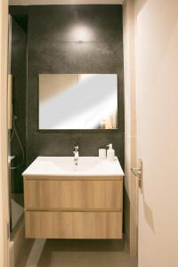 La salle de bains est pourvue d'un lavabo et d'un miroir. dans l'établissement Apart 2 Opera New 2-3 Rooms for 4 guests, à Paris