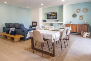 salon ze stołem i niebieską kanapą w obiekcie COAST WAY BEACH HOUSE w mieście Moledo