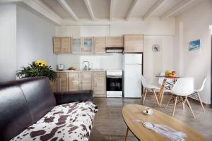 ein Wohnzimmer mit einem Sofa und einer Küche in der Unterkunft Green House 2 in Agioi Apostoli