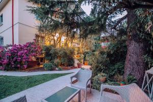 ogród z krzesłami, drzewem i kwiatami w obiekcie Bed&Breakfast Relax In The Lake w mieście Desenzano del Garda