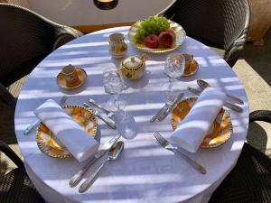 Villa Le Baste في فوروري: طاولة بيضاء عليها صحون و فضيات