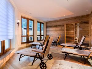 una habitación con sillas y una habitación con paredes de madera. en SCOL Sporthotel Großglockner, en Kals am Großglockner