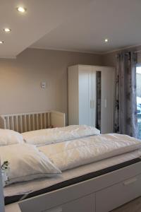 a bedroom with a large bed with white sheets at Augustenhof Ferien in Nordborg