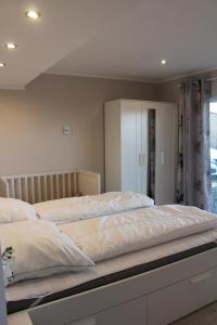 una camera da letto con un grande letto con lenzuola bianche di Augustenhof Ferien a Nordborg