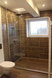 baño con ducha, aseo y ventana en Augustenhof Ferien, en Nordborg